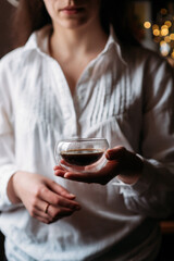 a girl in a white shirt pours milk from a white milk jug into an espresso coffee in a transparent cup, drops of milk in the air, bokeh, coffee with milk, a woman drinks coffee