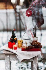 woman pours hot tea from a thermos in the cold, tea in the winter forest, except in a thermos