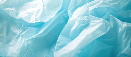 Obraz premium Light blue crumpled tissue paper texture showcasing soft folds and patterns for design and background use.