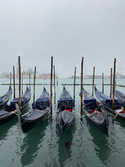 Obraz premium Gondolas boats under the rain moored at San Marco in the Grand Canal, Venice, Italy.
