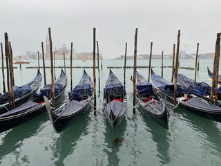 Gondolas boats under the rain moored at San Marco in the Grand Canal, Venice, Italy. © Ilya