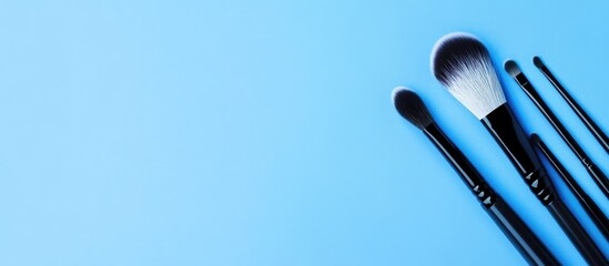 Array of professional cosmetic makeup brushes on a solid blue background with ample space for promotional text or product descriptions.