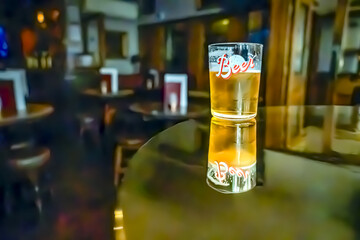 A glass of beer on the table. Bar in the blurred background with no people. 09/03/2024