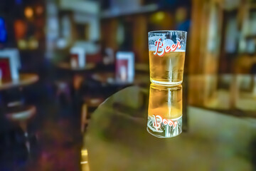A glass of beer on the table. Bar in the blurred background with no people. 09/03/2024
