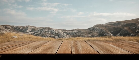 Obraz premium Scenic wooden table in foreground with expansive hill view and clear sky ideal for text overlay or marketing purposes