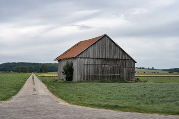 Obraz premium Large wooden barn for a farmer in a green field.