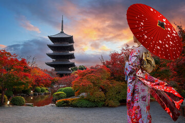 Fototapeta premium Japanese Woman in Traditional Kimono Dress at Toji Temple in Kyoto, Japan with beautiful garden and autumn foliage