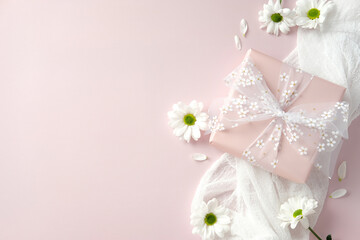 Flat lay composition with gift box and chamomile flowers on pastel pink background. Happy Mother's Day, birthday, International women's Day 8 march concept