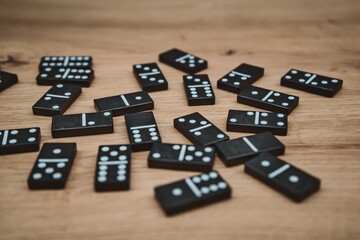 Scattered black domino tiles on wooden surface