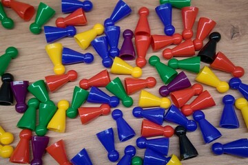Scattered colorful board game pieces on wooden surface