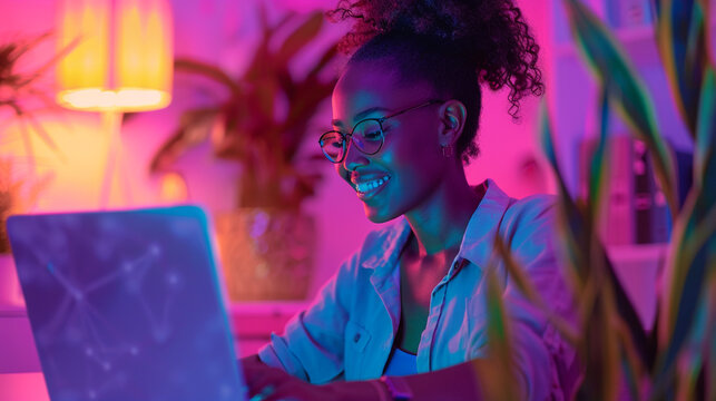 Smiling Woman Working at Laptop in Warm Light &ndash; Nighttime Productivity, Remote Work, Online Learning, or Freelancing from Home in a Cozy, Inspiring Environment Filled with Focus and Positive Energy