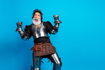 Energetic senior knight in armor cheerfully posing against a blue background, embodying humor and...