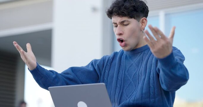 Student celebrating success on laptop outdoors
