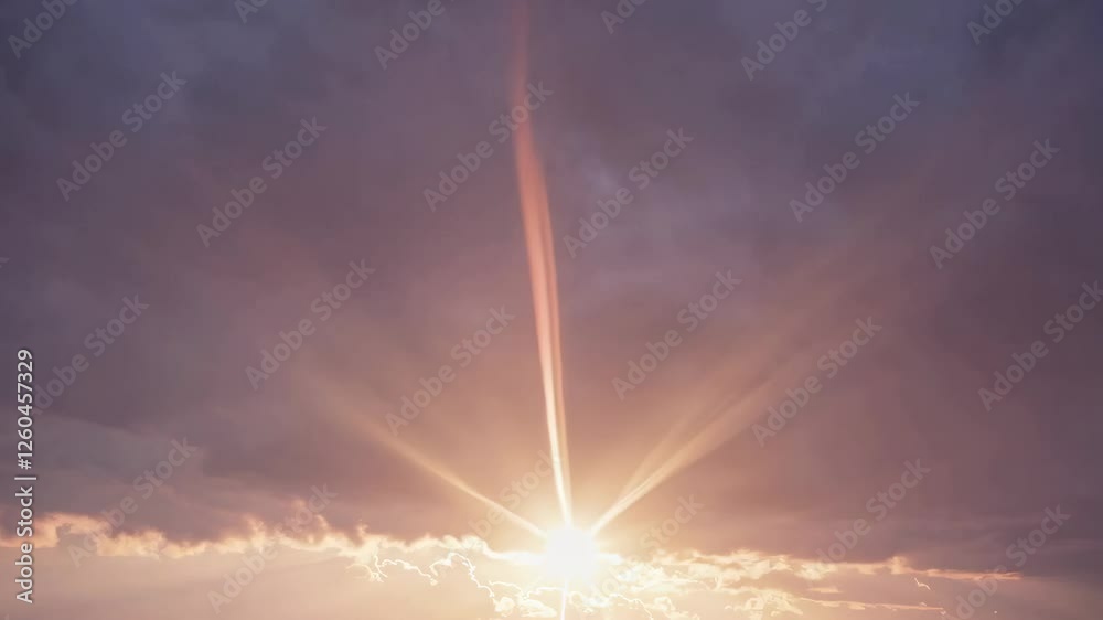 Poster Sun setting behind clouds with rays of light, dramatic sky at dusk. Nature and tranquility concept