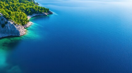 A stunning aerial view of clear blue waters meeting lush green coastline, showcasing nature's beauty and tranquility. Perfect for travel, relaxation, and environmental themes.
