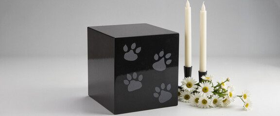 Elegant stone pet urn with candles and daisies, honoring memories