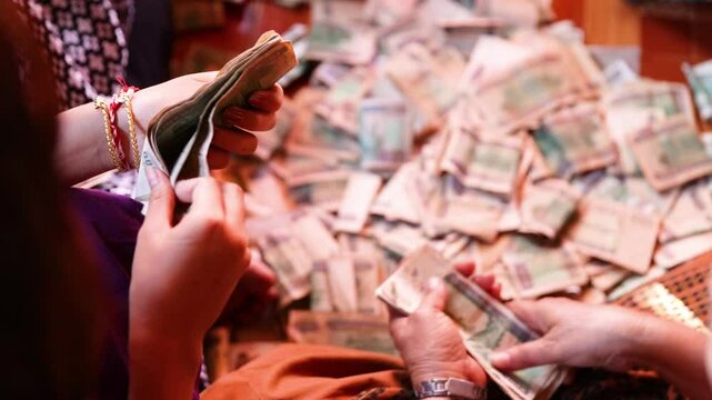A young girl's hands counting Burmese money. 1000 Kyat, MMK.