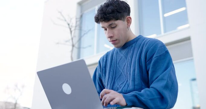 Young male using netbook outside building