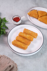 vegetables risoles or risol sayur or risoles sayur stuffed with veggies and enclosed in crepe-like wrappers and rolled into bread crumbs and fried. served on white plate and chili. selected focus	appe