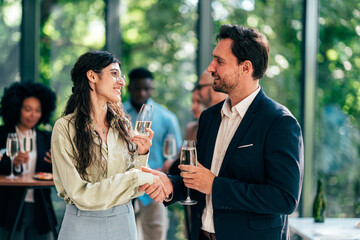 Businessmen and businesswomen making a corporate party after the business conference to celebrate the year goals and achievements.