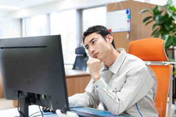 悩む、男性、オフィス、作業員、工場、中小企業、経営、PC、考える、疑問、不満、不安、心配、トラブル、問題、困る、悩み、仕事、バックオフィス、デスクワーク、産業、製造業、人事、労務、管理、コスト、経費、費用、モニター、DX、電子化、ストレス、人手不足、求人、採用、作業服、エンジニア、スタッフ、事務所、建築、建設、工事、工務店、管理職、失敗、パソコン、日本人、技術者、会社員、人物