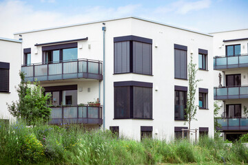 Modern Residential Apartment Building with White Facade and Green Landscaping in Europe. New Low rise Multistory Tree-story Multifamily Three leaf Building