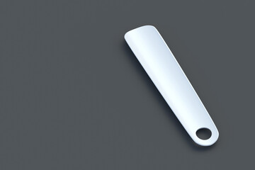 White shoehorn on gray background. Plastic shoe spoon. Copy space.  3d render