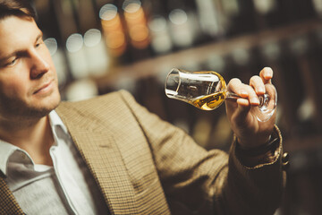 Portrait of male sommelier tasting whiskey at cellar.