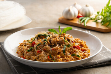 Stir fried minced Pork with Thai Holy Basil and Glass Noodles in white plate.
