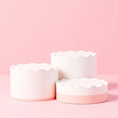 three elegant cylindrical displays in soft white and pale pink