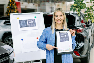 Saleswoman showing infographic during presentation about automotive suspension performance in car dealership