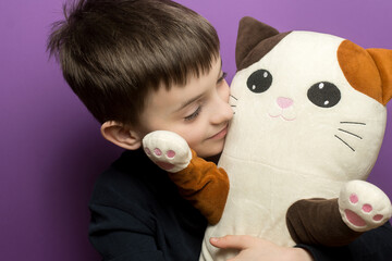 A happy child hugging a cute plush cat toy, expressing warmth, love, and comfort. The close-up captures the joy of childhood with a soft and cozy atmosphere.