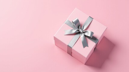 Fototapeta premium A Pink Gift Box with a Silver Ribbon Bow on a Pink Background