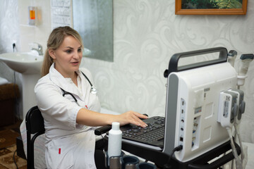 A woman doctor with stethoscope performs an ultrasound exam using a modern machine in a clinical...