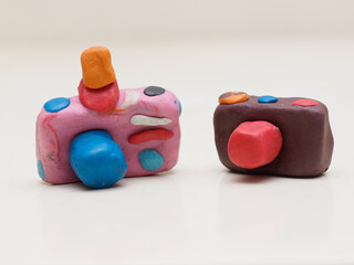 Children made miniature clay cameras one in pink color and another in brown with cute and colorful...