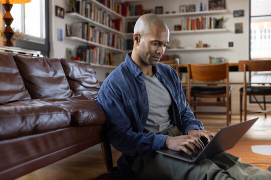 Man Deeply Engaged with Laptop in Living Room