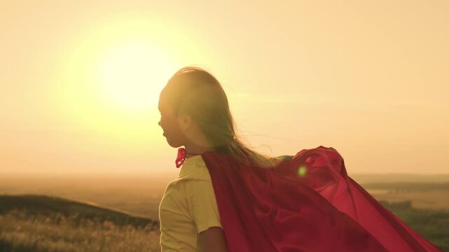 girl superhero sunset glare. game teenager red raincoat top mountain. glare sun sky. brave superhero meets day dawn. children dream. girl red raincoat wind. superhero costume. child pray wind sun.