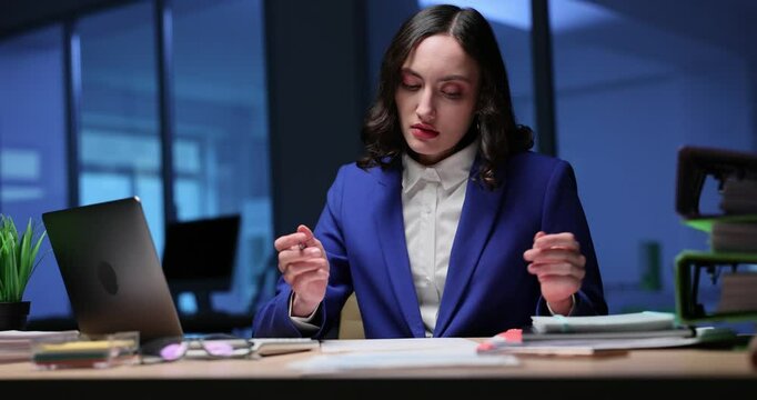 Angry woman manager checks report crossing wrong blocks at late hours in office. Woman analyzes business papers preparing commercial presentation