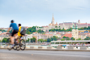 Fototapeta premium Budapest old city view with two defocused bicyclist riding