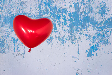 Red heart shaped balloon on blue background. Valentine's day concept.