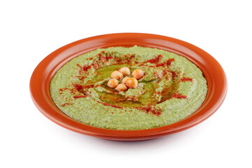 Delicious green hummus with chickpeas and paprika in a clay dish