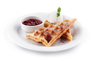 Delicious waffles with strawberry jam and ice cream are lying on white plate