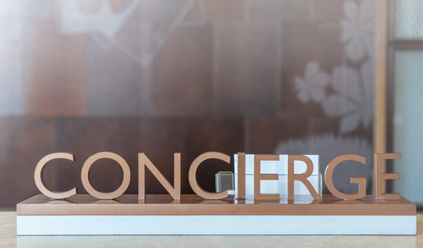 Concierge service desk counter with staff team working in front of hotel with tourist business customer.