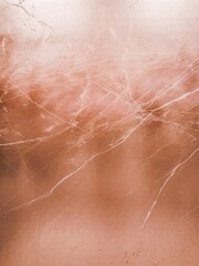 Fototapeta premium Abstract close-up of rose gold surface, featuring subtle texture and delicate white veining.