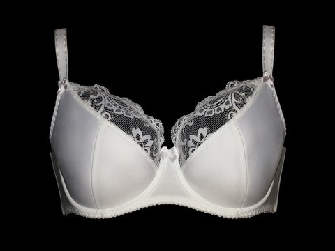 White fashionable lace bra on a black background.