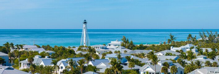 Famous lighthouse on ocean shore and expensive residential houses in island small town Boca Grande...