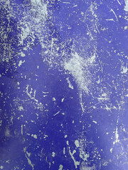 Worn purple paint on metal sheet texture background. Old purple concrete surface. Purple enamel paint cracks and shows the metal inside.