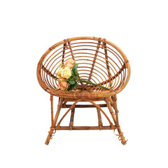 Garden wooden rattan chair seating with rose flower decoration on top isolated on white background.