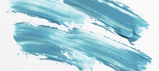 Bold, vibrant strokes of blue paint are applied on a white surface, showcasing artistic creativity and texture