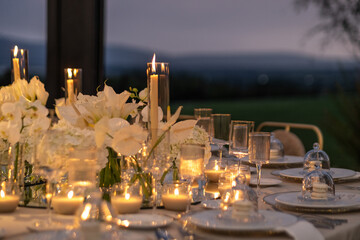 candlelit dining table setting against mountain landscape